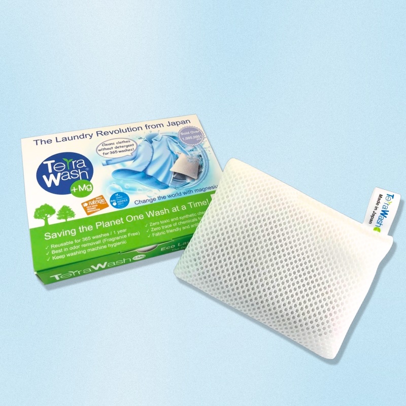 A white box with a shirt pictured on it and the words Terra Wash +Mg, The Laundry Revolution from Japan, next to a white rectangular sachet.