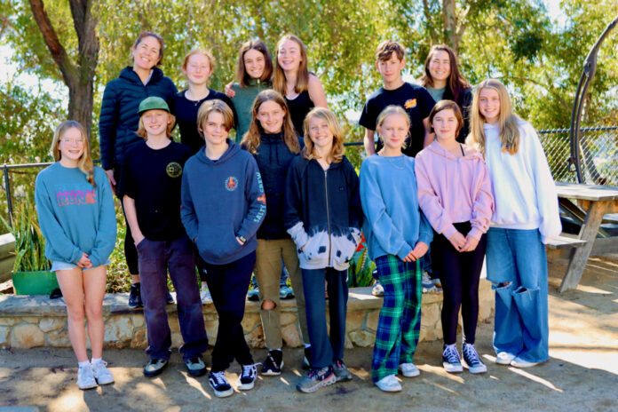 Group of students and teachers standing outside in a group, facing the camera.