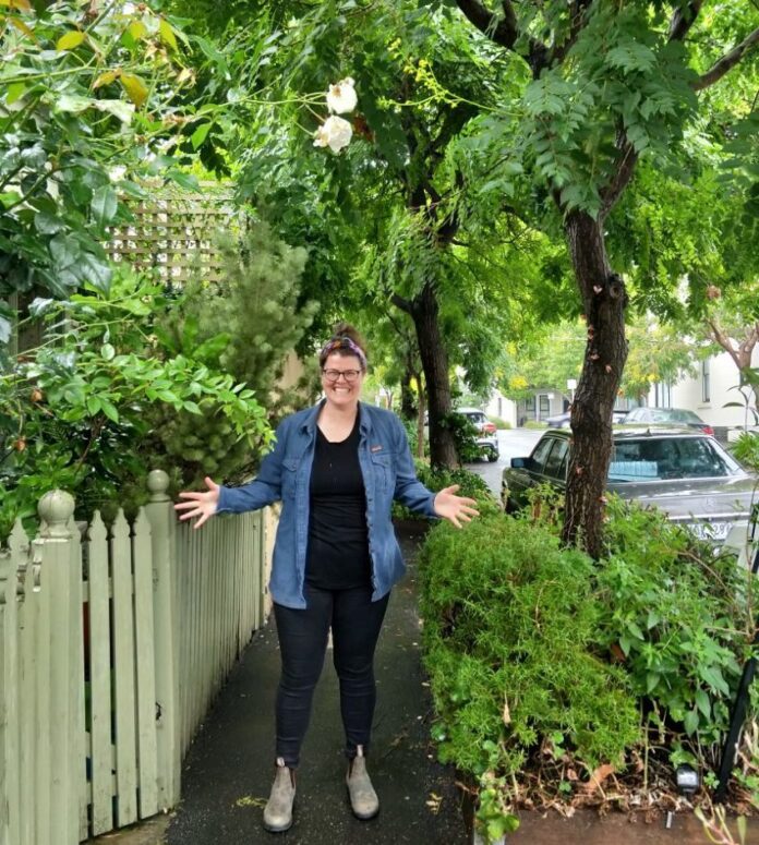 A woman stands with her hands out in a jazz hands position.