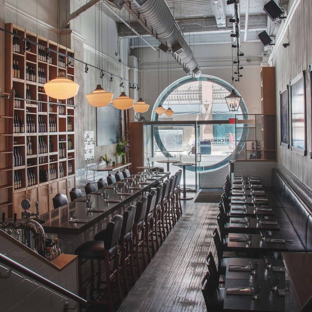 Interior of restaurant with lots of chairs and tables and large circular window