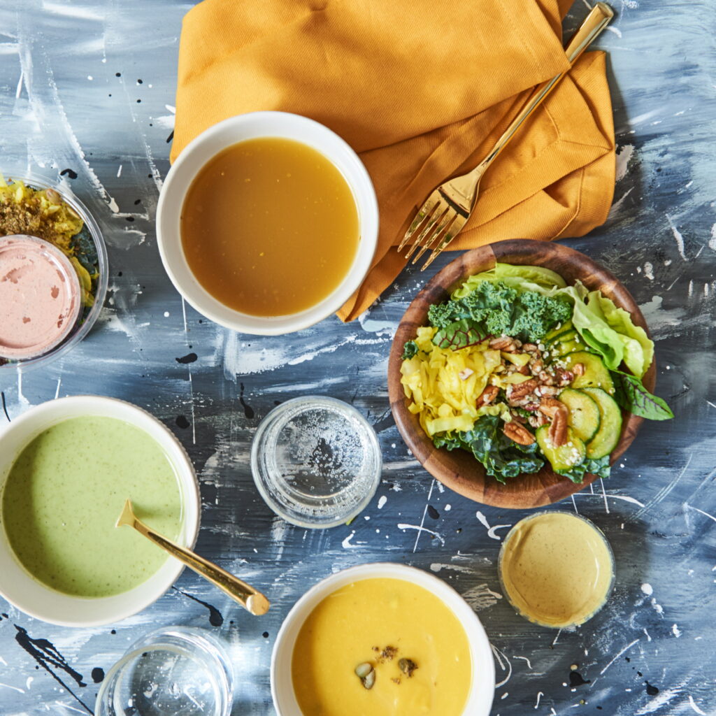 overhead shot of a table with vegan soups, salad and other dishes.