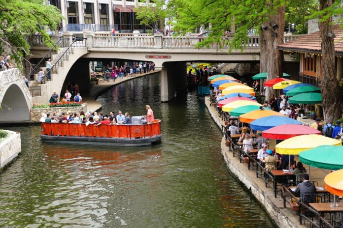 riverside dining with colorful umbrellas and boat in water