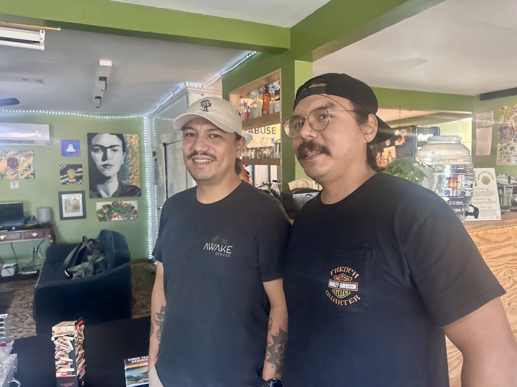 two men wearing baseball hats in restaurant