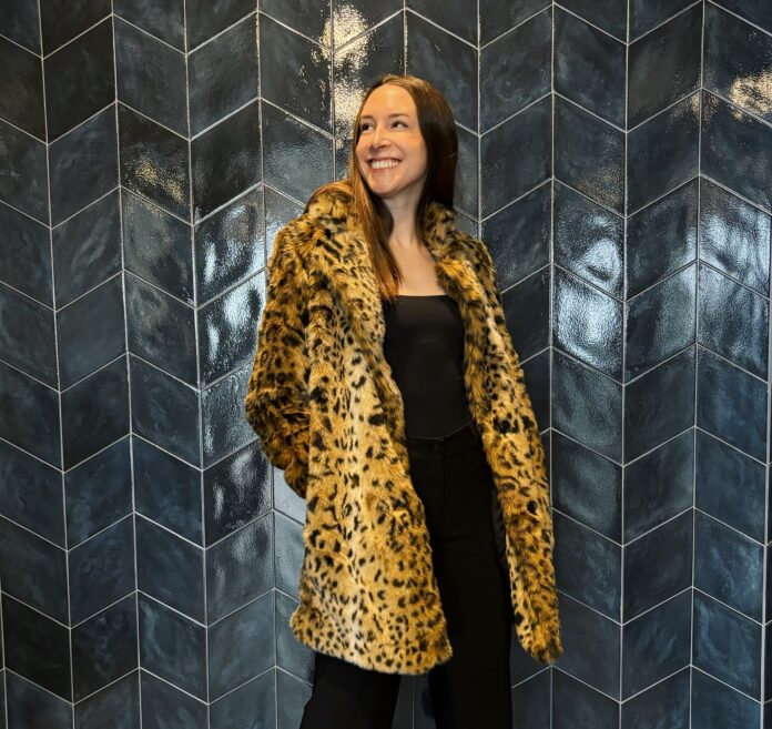 a young woman wearing a leopard-print faux fur jacket