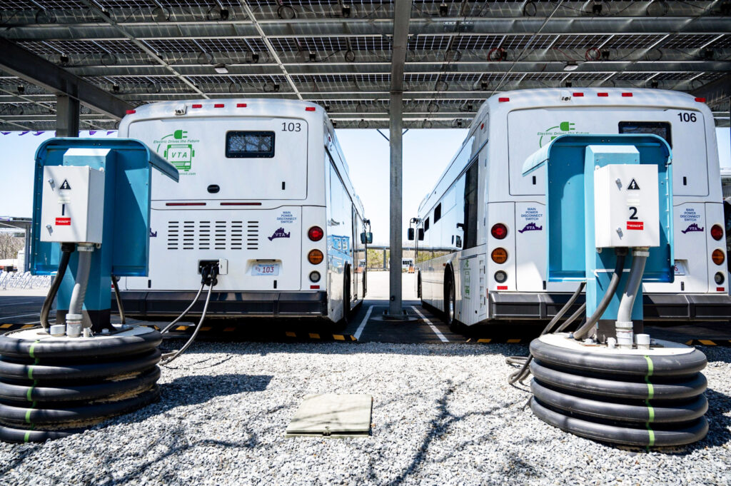 two electric busses at charging stations