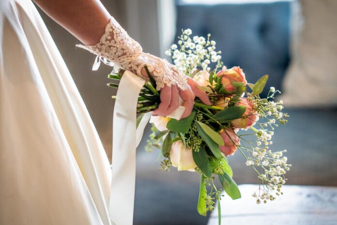 a bride holds a bouquet of pink and white flowers