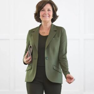 A woman in her 50s with short brown hair wearing an olive green blazer
