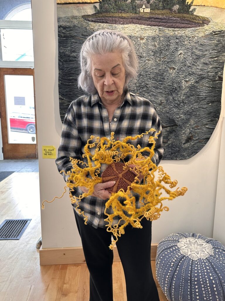 Laurie Swim holding an orange brittle star made out of fabric