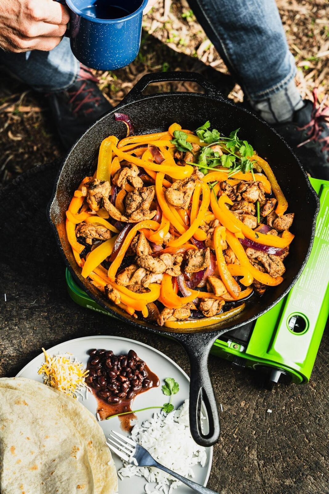 fajitas made outdoors on a skillet over a fire