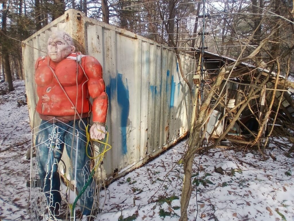 a sculpture of a man in front of a shipping container