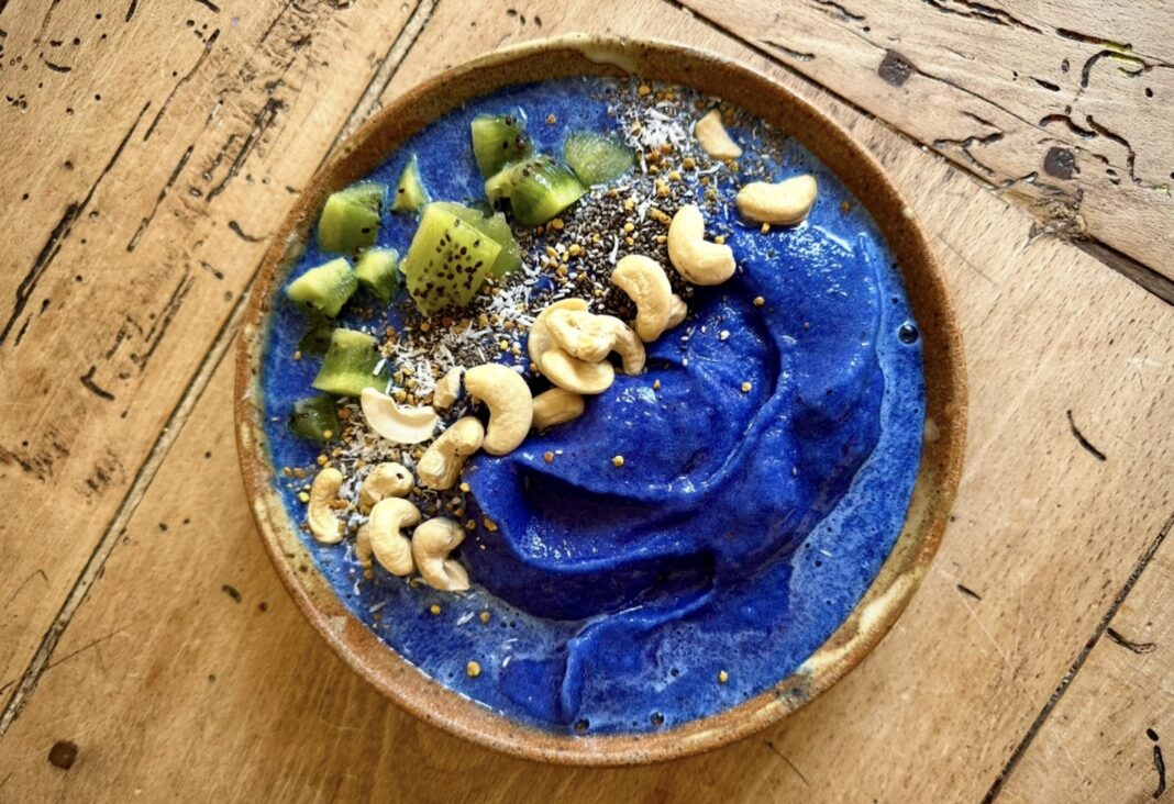 a blue spirulina mermaid bowl filled with colorful fruits