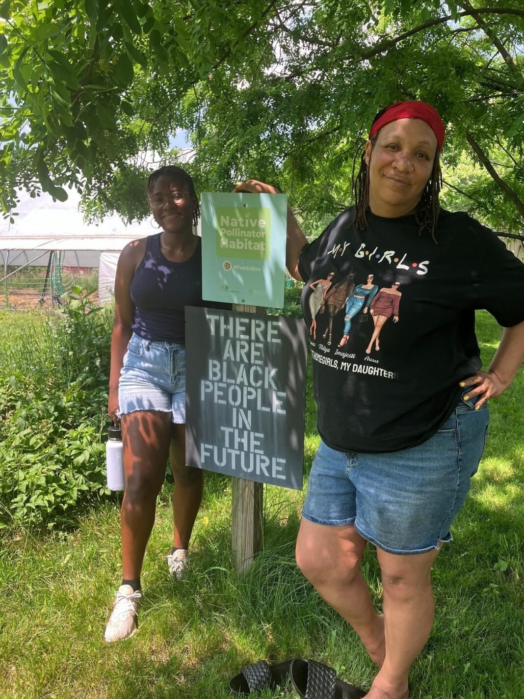 two black women stand in a community garden that they tend to