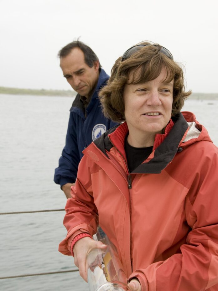 a man and woman holding glass tubes on a boat