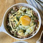 porridge topped with oil-fried eggs and aged cheese
