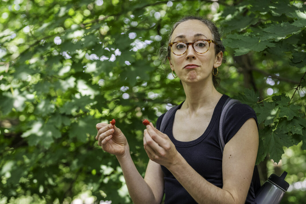 Caroline Saunders takes a bite out of fruit that she's foraged in new york