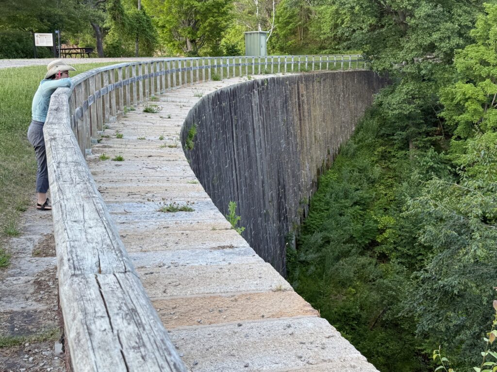 a woman stands at the Great Stone Arch Dam at Jones Falls