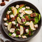 chopped chicken salad topped with fruit and nuts