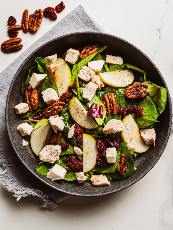 chopped chicken salad topped with fruit and nuts