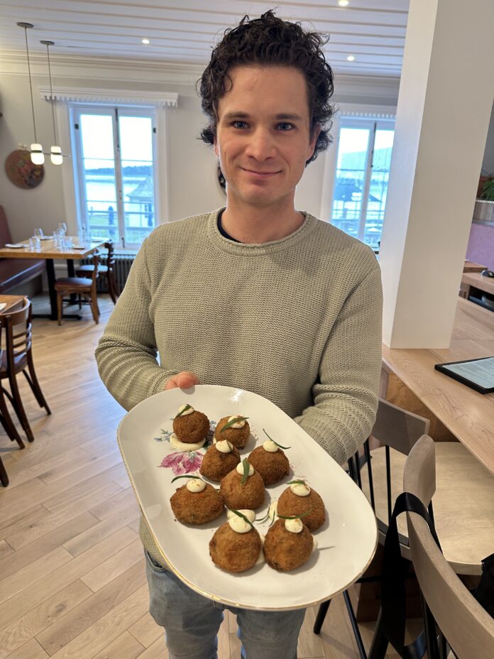 a man offering arancini balls