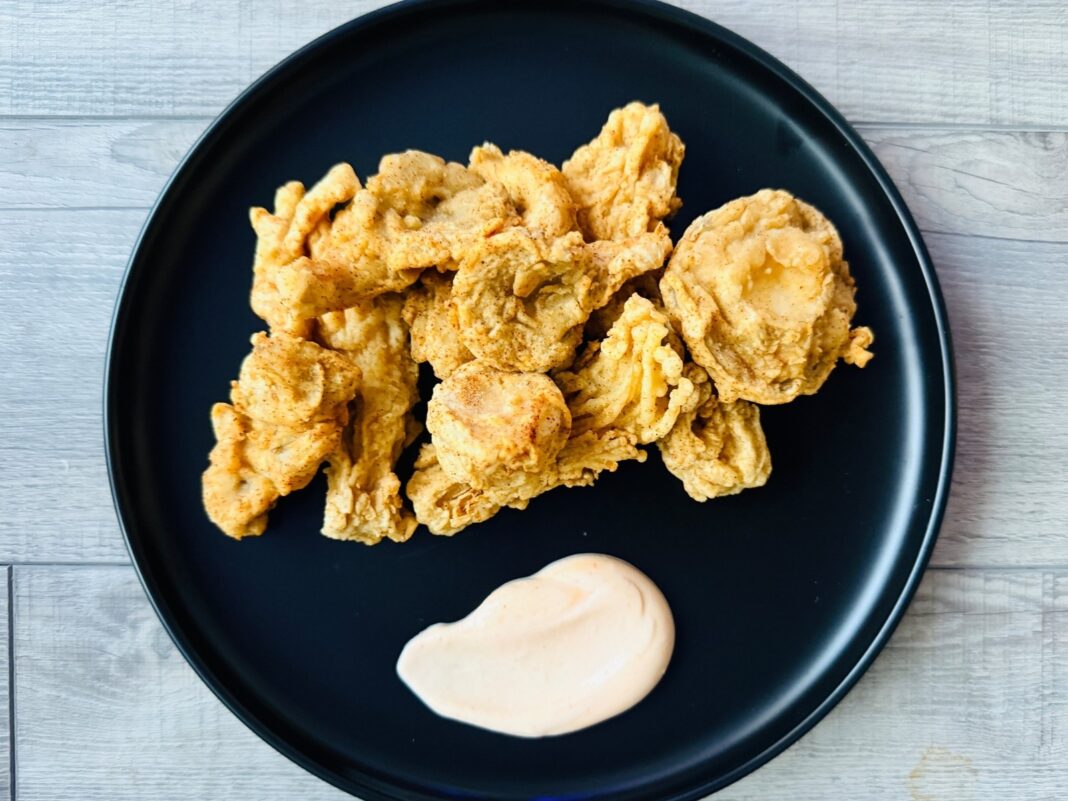 beer-battered mushrooms on a plate with a side of spicy aioli