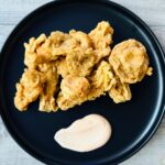 beer-battered mushrooms on a plate with a side of spicy aioli