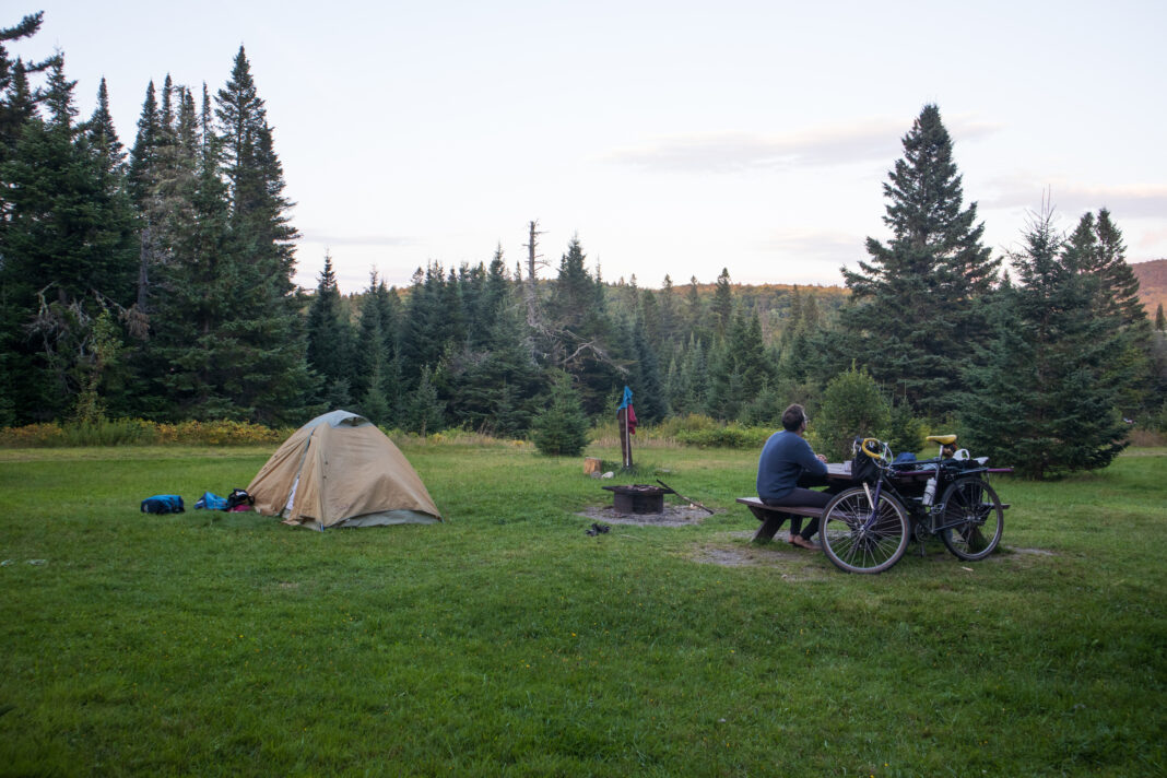 sam moore sits at a campsite at baxter state park