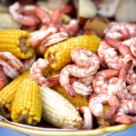 a low country shrimp boil served on a light blue tablecloth