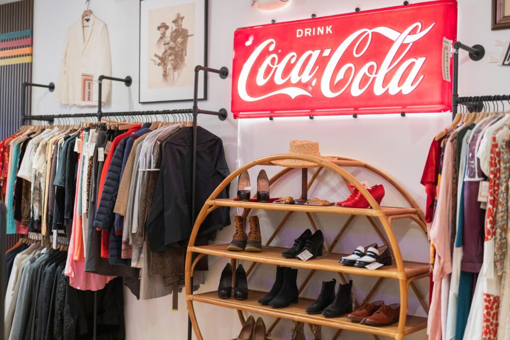 the inside of island vintage shoes clothes on racks and a large coca cola sign