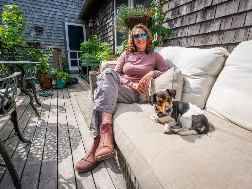 jennie and her pup sit on a couch outside