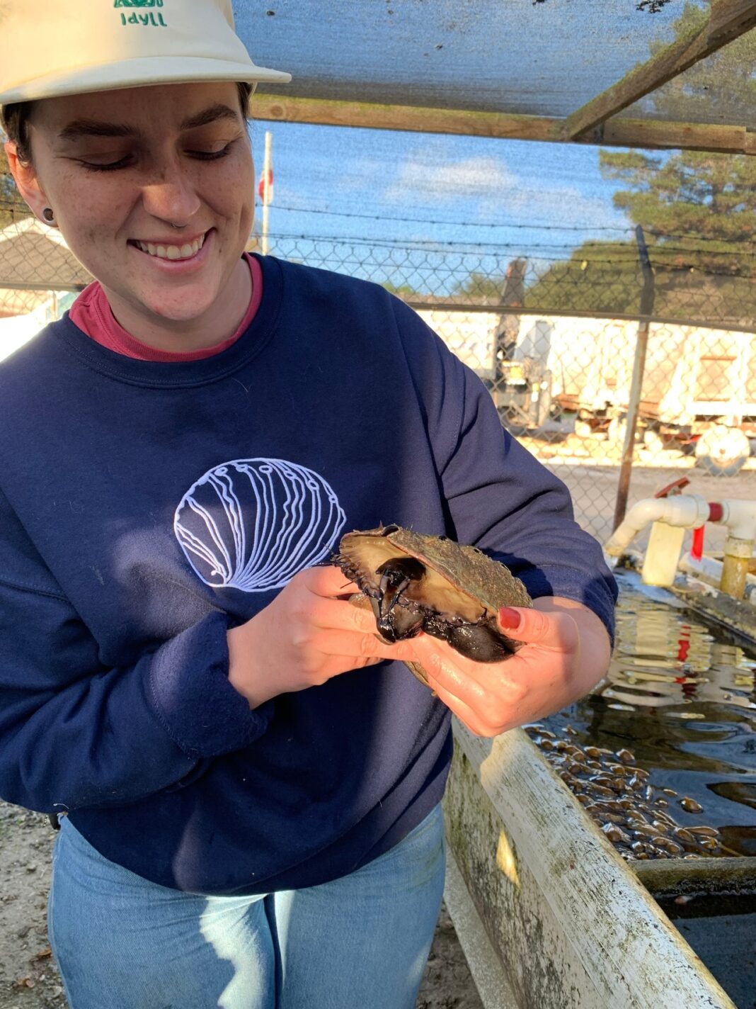 Andie Van Horn, farm-to-table manager at the Cultured Abalone Farm, holding an abalone