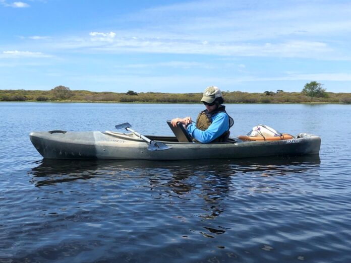 rj turcotte sits in a canoe on the water