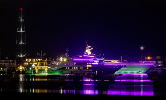 nantucket harbor at night with a bright light-up ship