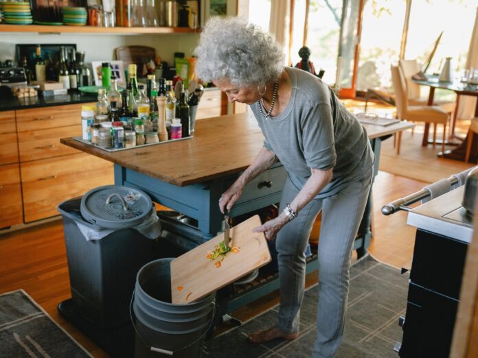 a woman composting food in her kitchen