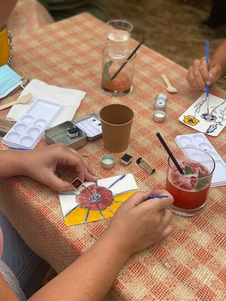 a person painting a flower at a paint-and-sip workshop