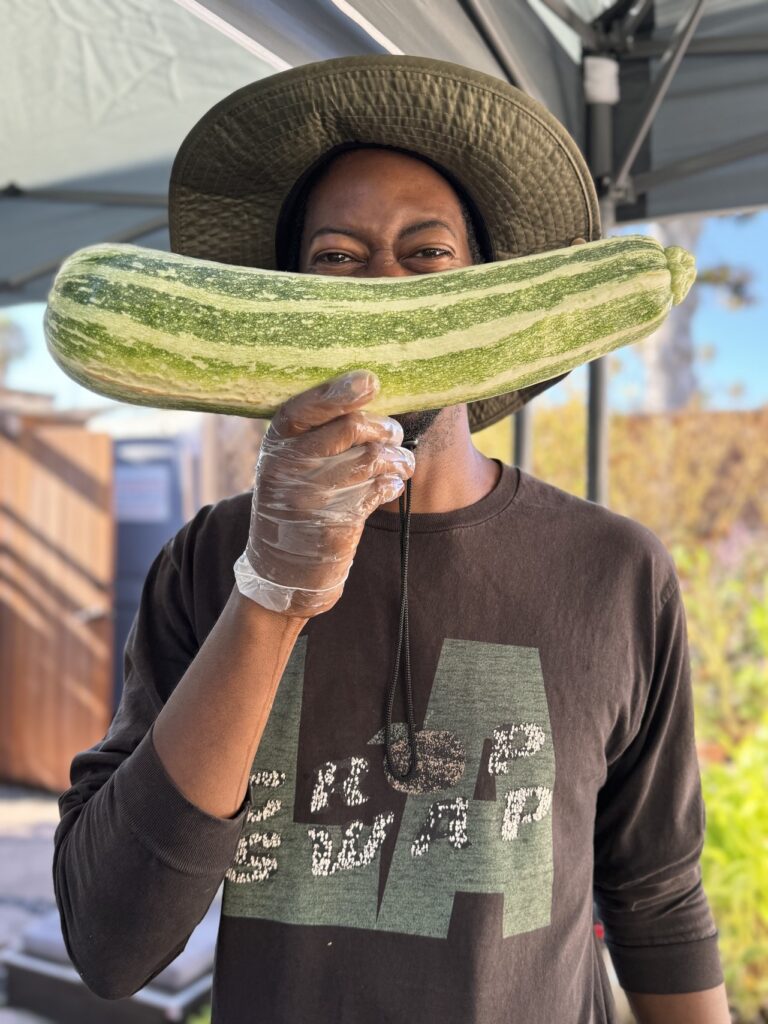 a man holding a large zucchini in front of his face