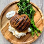balsamic-soy marinated portobello steaks with rosemary served on a wooden plate