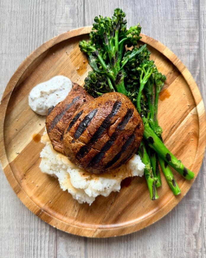 balsamic-soy marinated portobello steaks with rosemary served on a wooden plate