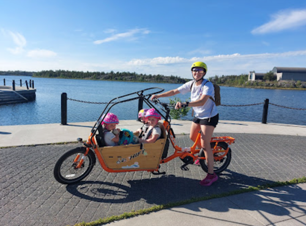 a woman cycling with her kids