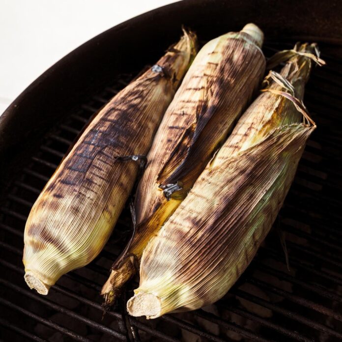 three pieces of corn grilled in the husk