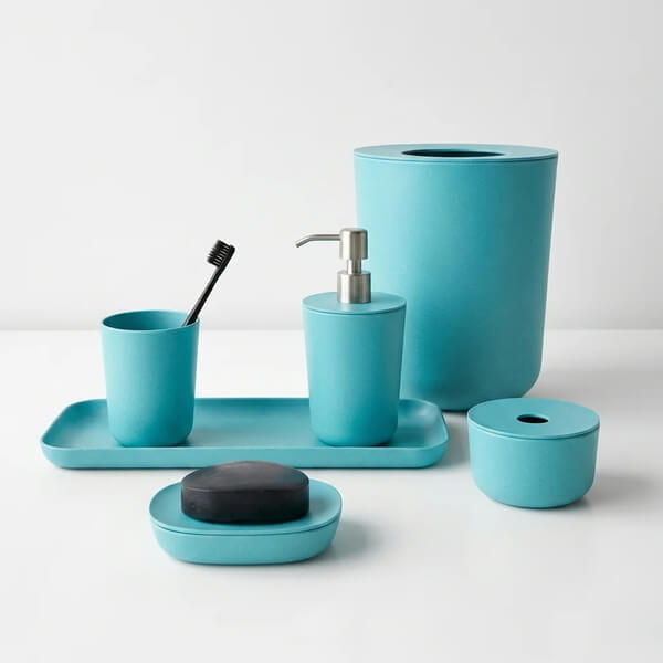 a set of turquoise bathroom accessories, including a soap dish, toothbrush holder, and trash bin