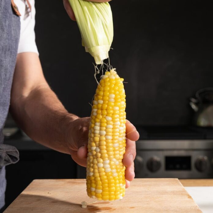 peeling the husk off of corn that's been microwaved