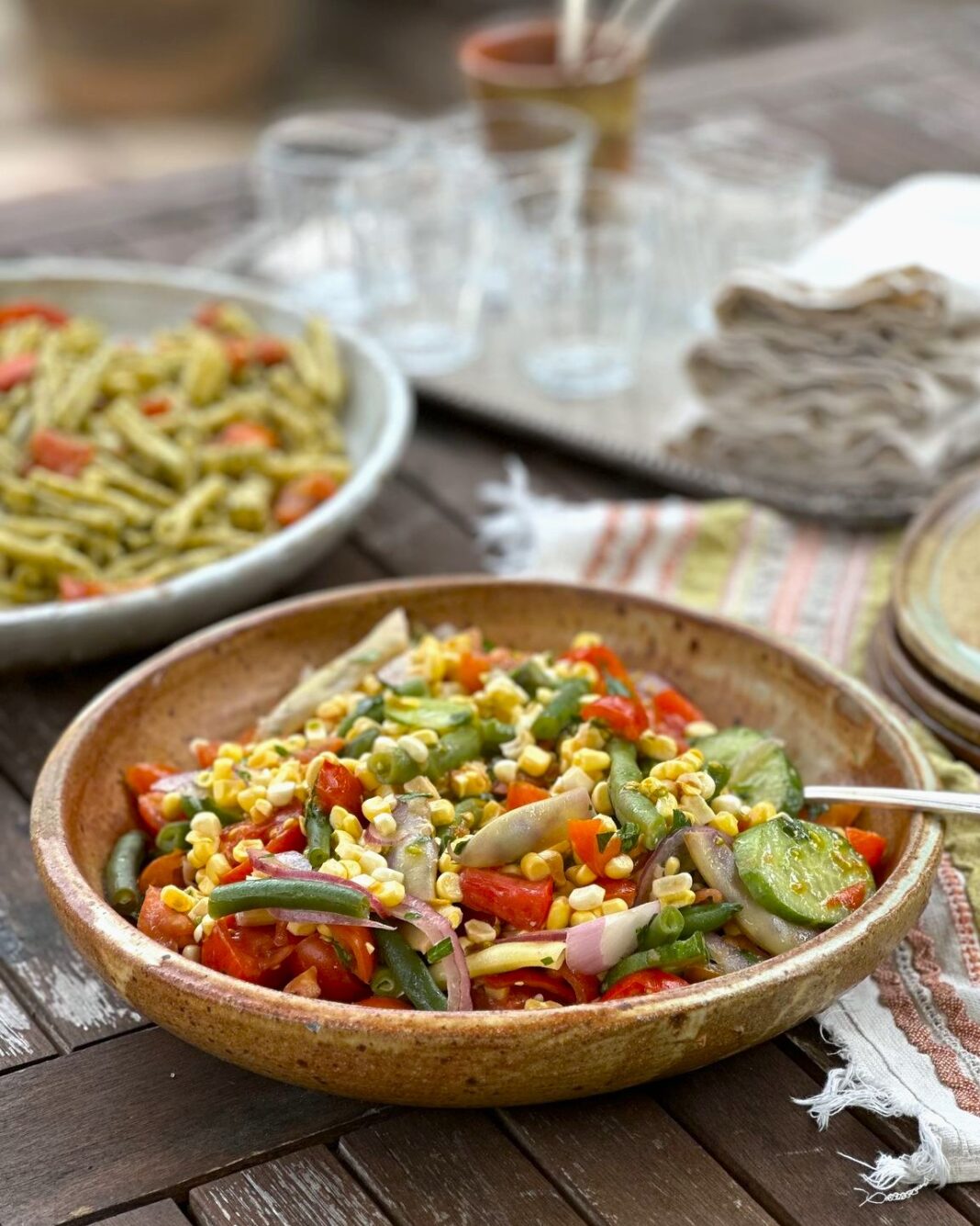 summer salad and pasta served on plates outdoors